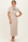 woman wearing a beige ribbed midi dress with short sleeves and a bow detail at the neckline