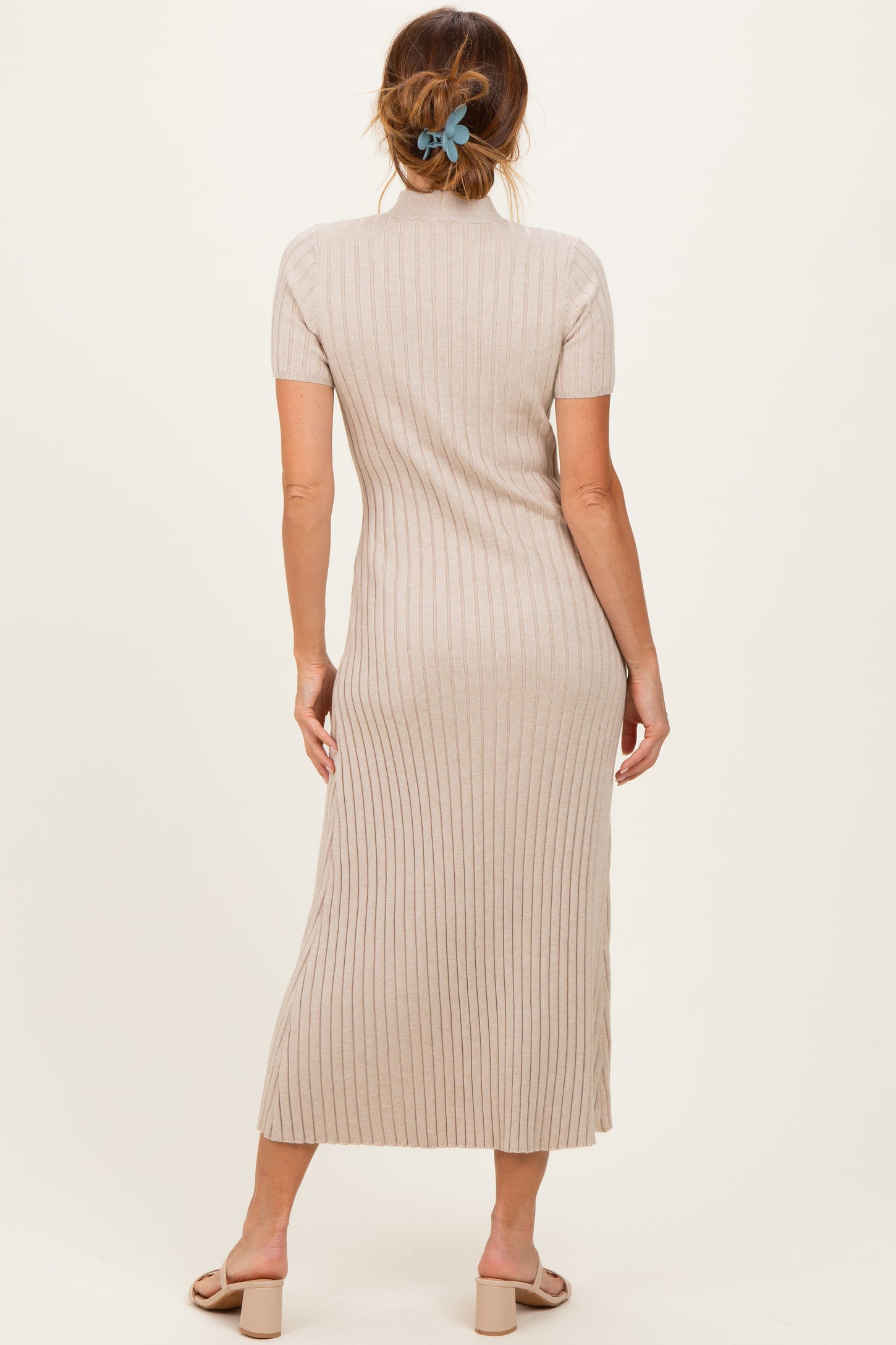woman wearing a beige ribbed midi dress with short sleeves, standing with her back to the camera