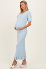 woman wearing a light blue ribbed maternity dress with short sleeves and a flounced hem, showing her baby bump