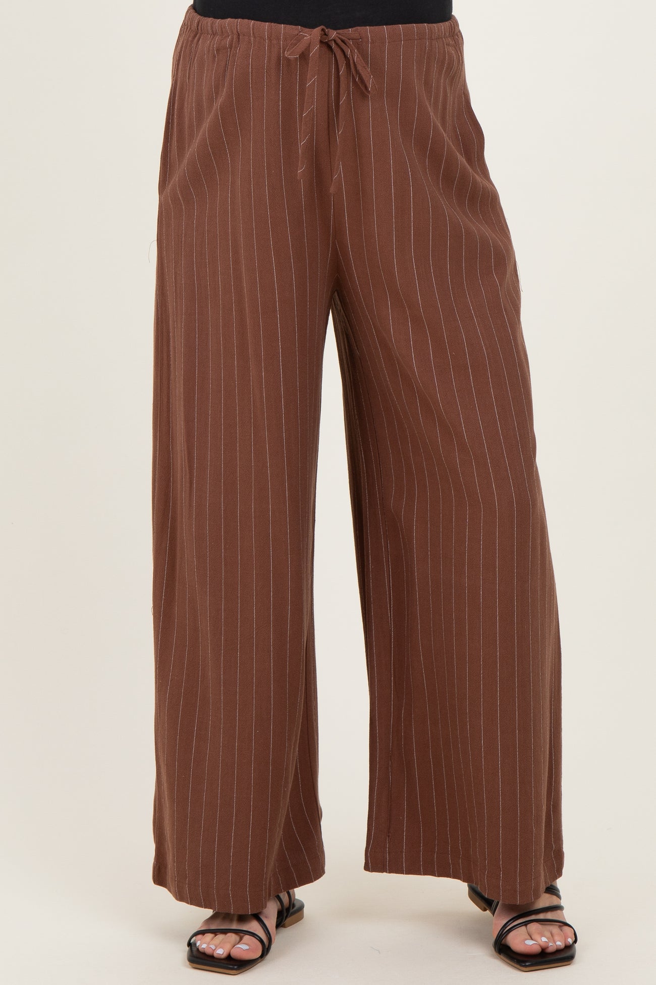 maternity wear brown striped wide-leg pants with an elastic waistband and tie detail, styled with a black top