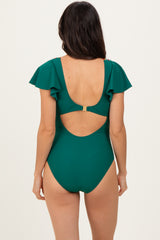 woman wearing a teal one-piece swimsuit with ruffled sleeves and an open back detail
