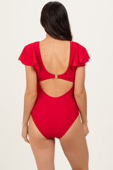 woman wearing a red one-piece swimsuit with ruffled sleeves and an open back detail