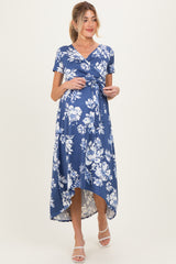 woman wearing a blue floral wrap maternity dress with a high-low hem and short sleeves, showing her baby bump