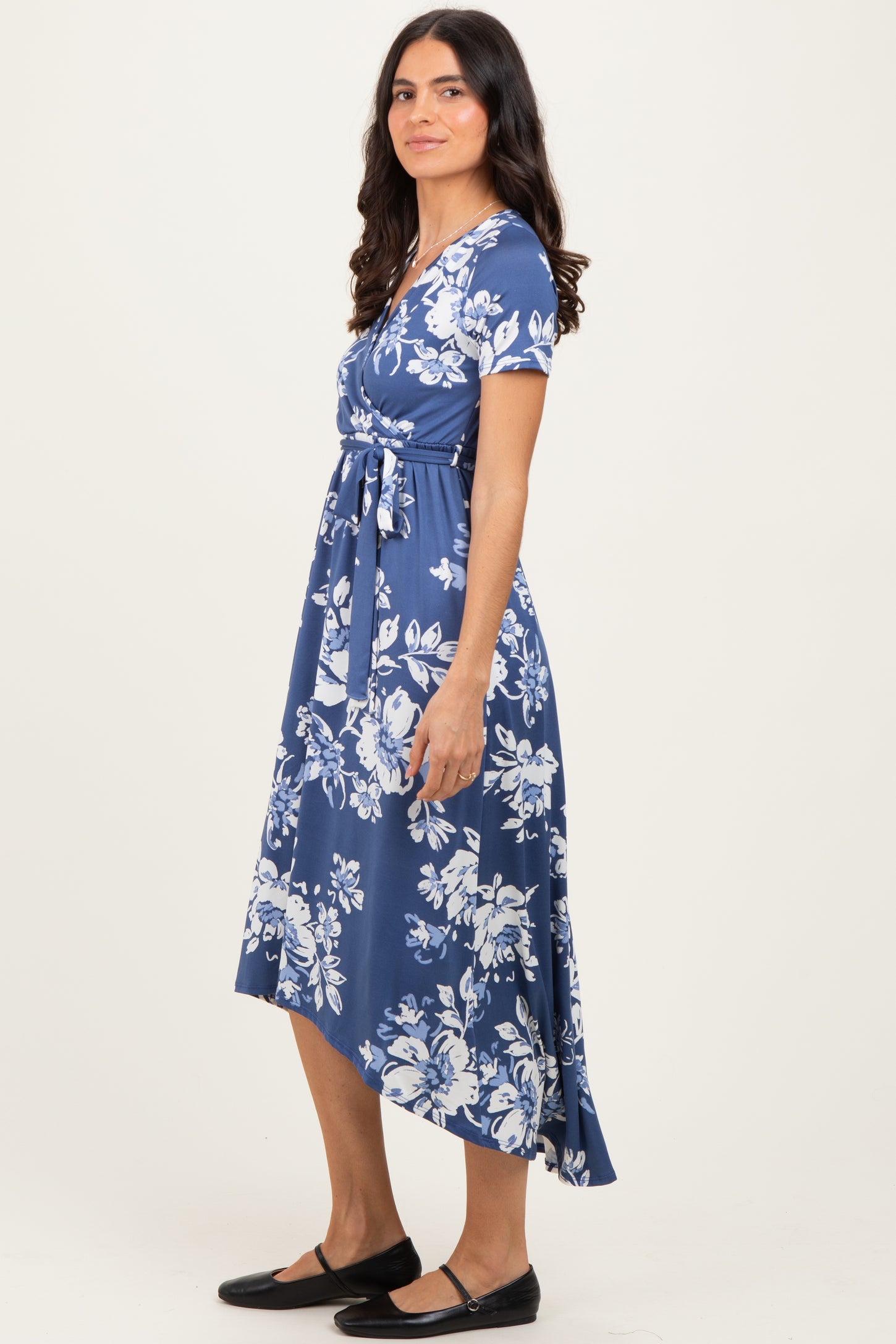 woman wearing a navy blue floral print midi dress with a belted waist and short sleeves