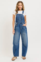 woman wearing a white t-shirt and blue denim overalls with side pockets and loose fit