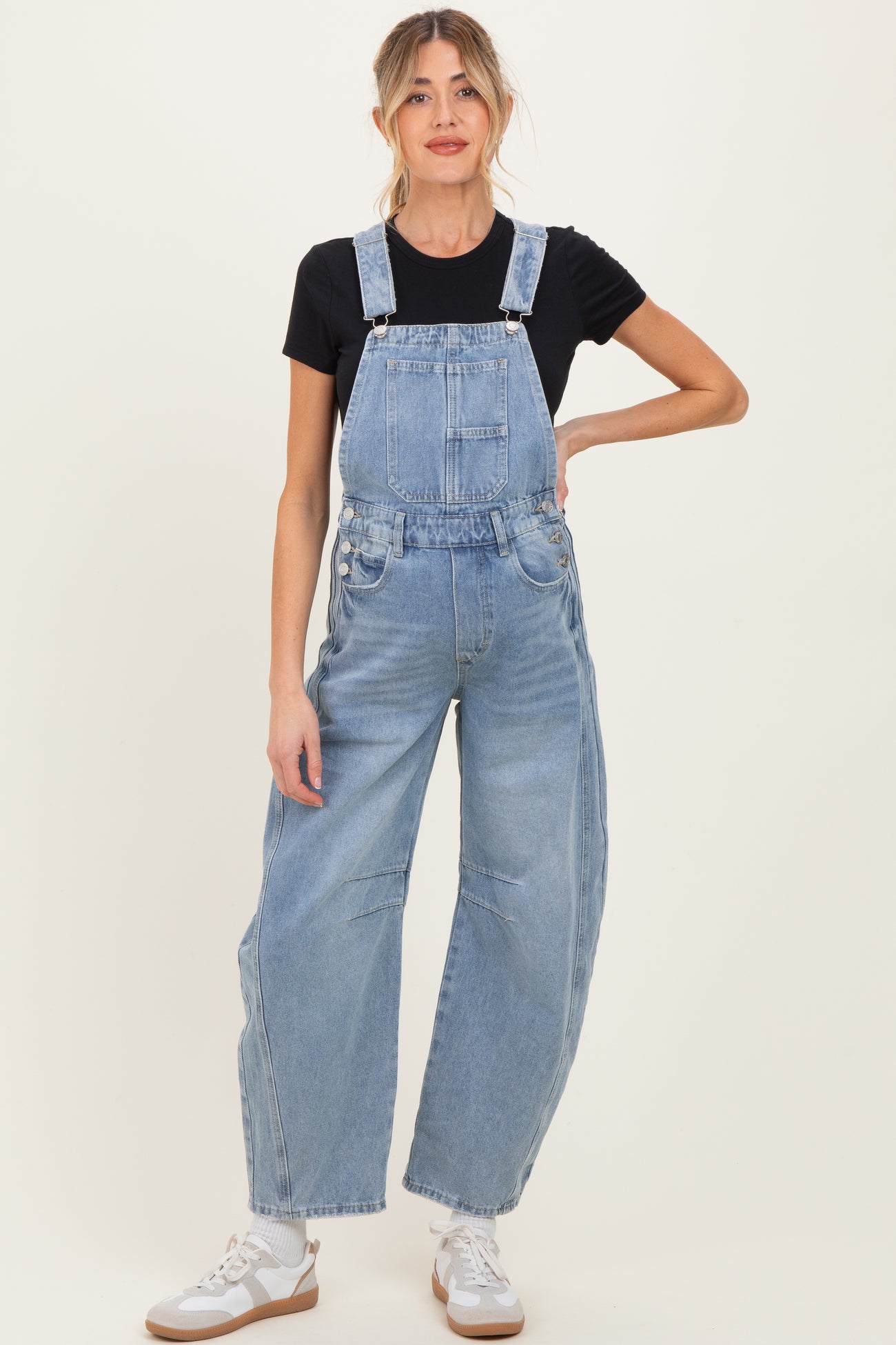 woman wearing light blue denim overalls paired with a black t-shirt, suitable for maternity wear