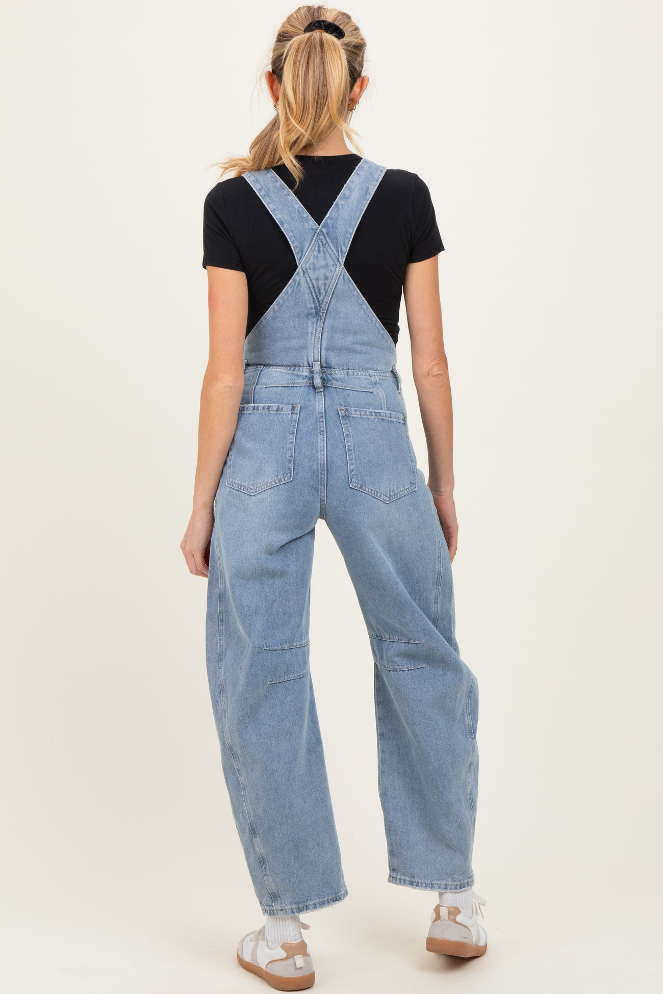 woman wearing light blue maternity overalls with a relaxed fit, showing the back view