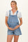 woman wearing a light blue denim maternity overall shorts and holding her baby bump
