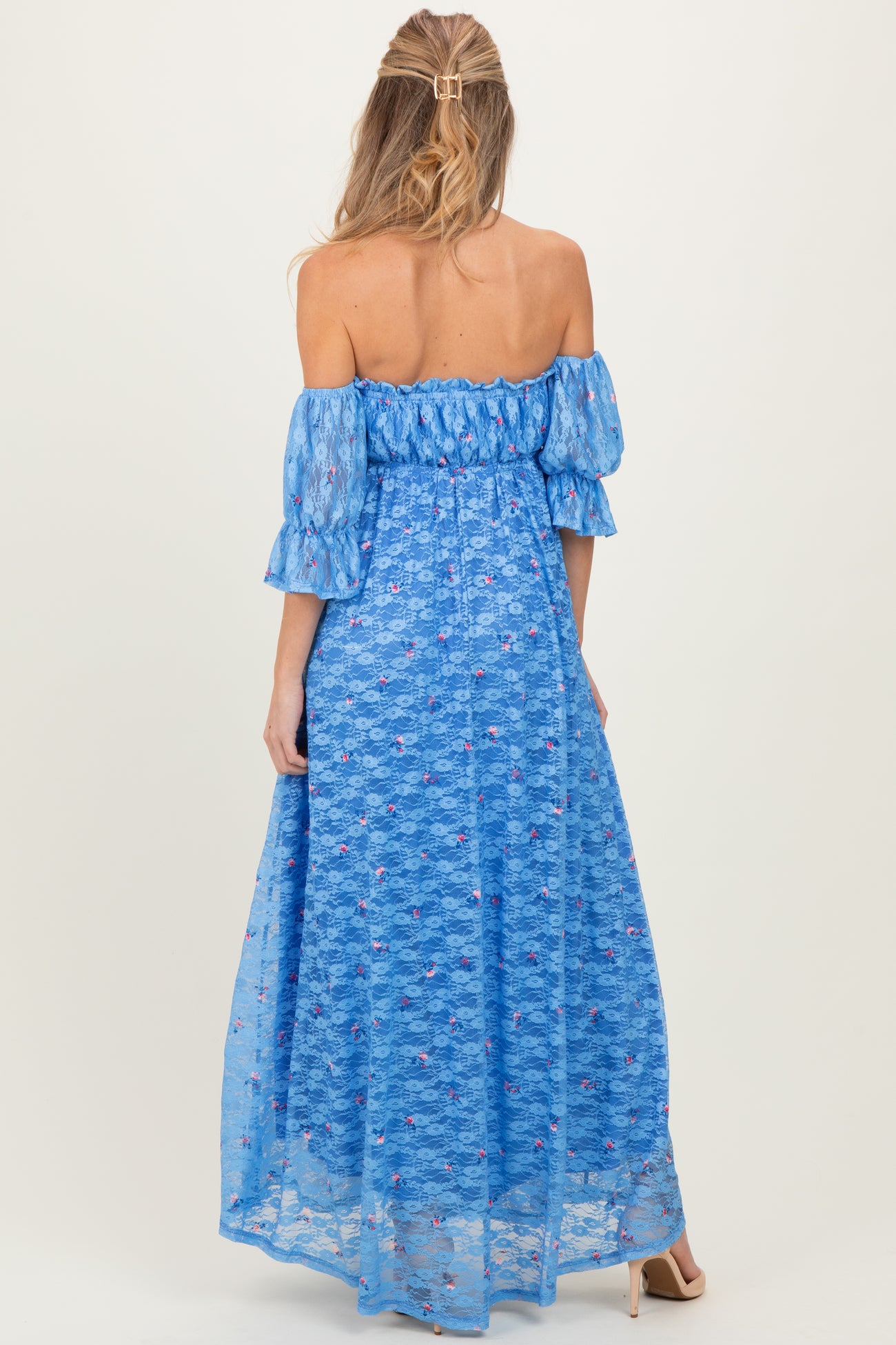 woman wearing a blue off-the-shoulder maternity dress with flutter sleeves and floral lace detailing