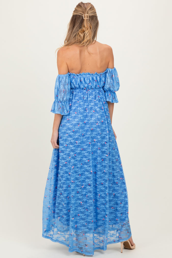 woman wearing a blue off-the-shoulder maternity dress with flutter sleeves and floral lace detailing