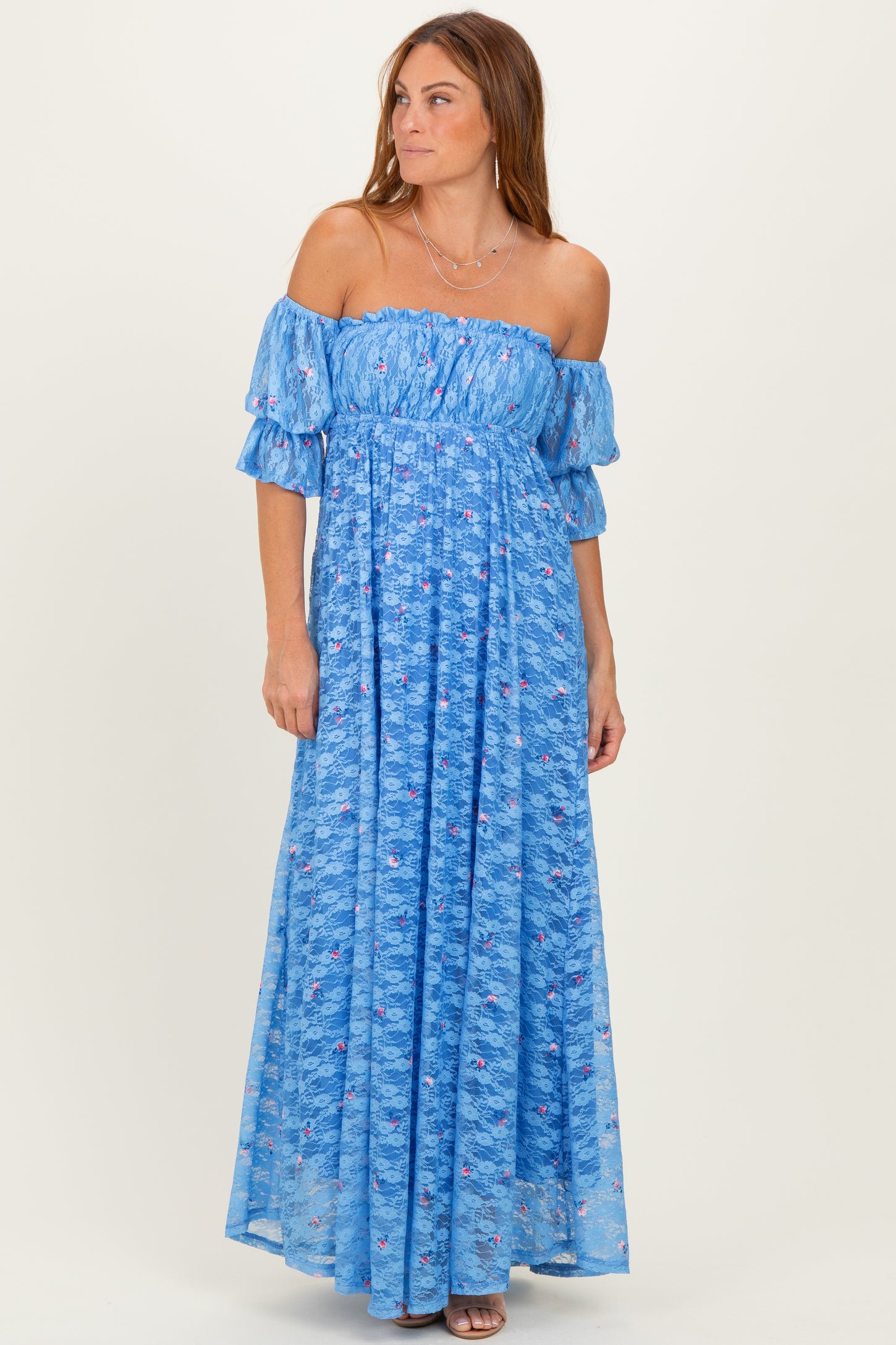woman wearing a blue off-the-shoulder maxi dress with short puff sleeves and floral print