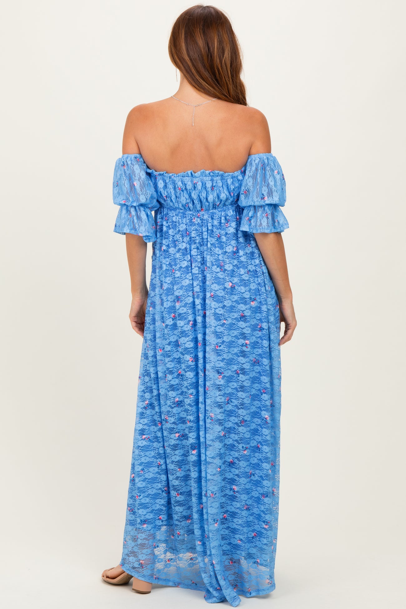 woman wearing a blue off-shoulder maxi dress with puff sleeves and a smocked bodice, seen from the back