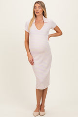 woman wearing a light pink maternity dress with a polo collar and fitted style, showcasing her baby bump