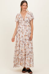 woman wearing a floral printed white maternity maxi dress with short sleeves and a tie front detail, showcasing a baby bump