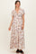 woman wearing a floral printed white maternity maxi dress with short sleeves and a tie front detail, showcasing a baby bump