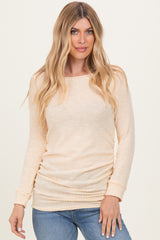 woman wearing a light peach long sleeve ribbed top and blue jeans