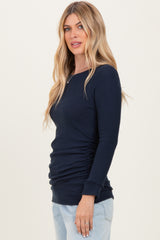 woman wearing a navy ribbed long sleeve top with side ruching and a fitted silhouette