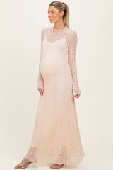woman wearing a light peach long sleeve maternity dress with a lace design and a visible baby bump