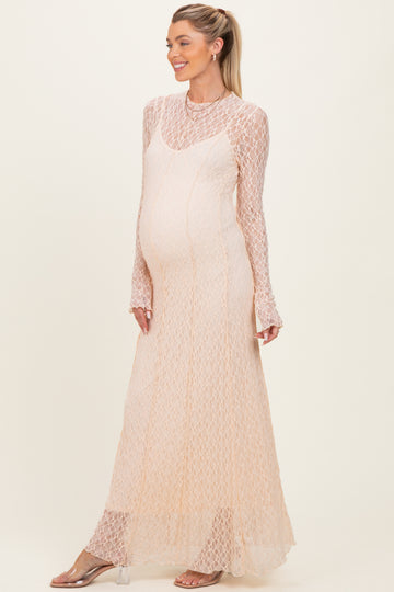 woman wearing a light peach long sleeve maternity dress with a lace design and a visible baby bump