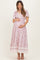 woman wearing a floral print maternity maxi dress with short sleeves and a v-neck, holding her baby bump