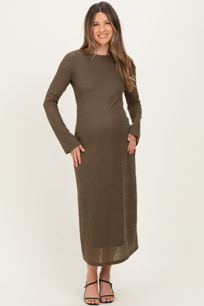 woman wearing a dark olive long sleeve maternity dress with a fitted silhouette and a visible baby bump