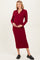 woman wearing a wine red long sleeve maternity dress with a collar and holding her baby bump