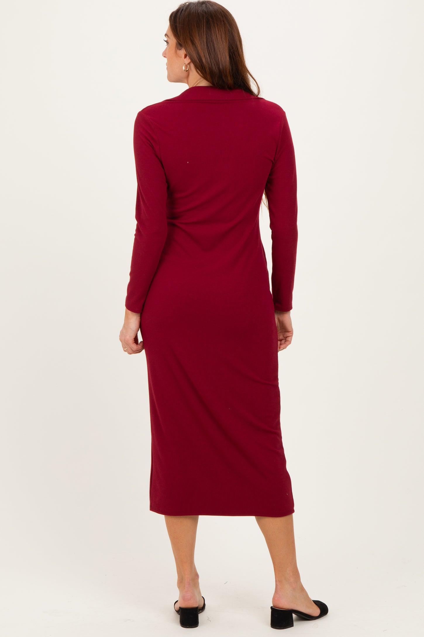 woman wearing a burgundy long sleeve midi dress, shown from the back with a fitted silhouette and a collar