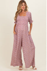 woman wearing a floral print maternity maxi dress with puff sleeves and pockets, showcasing her baby bump