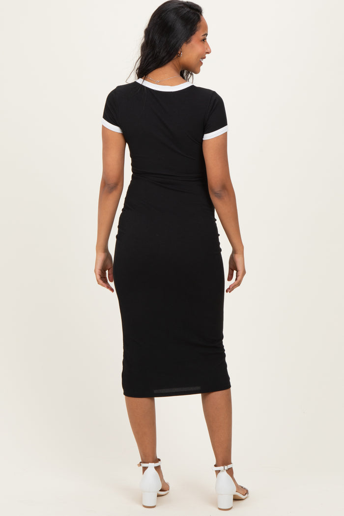 woman wearing a black maternity dress with white trim, showing a fitted style and a visible baby bump from the back