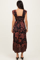 woman wearing a black floral maxi dress with ruffled sleeves and a tiered skirt, shown from the back