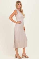 woman wearing a neutral ribbed midi dress with a sleeveless design and a flared hem