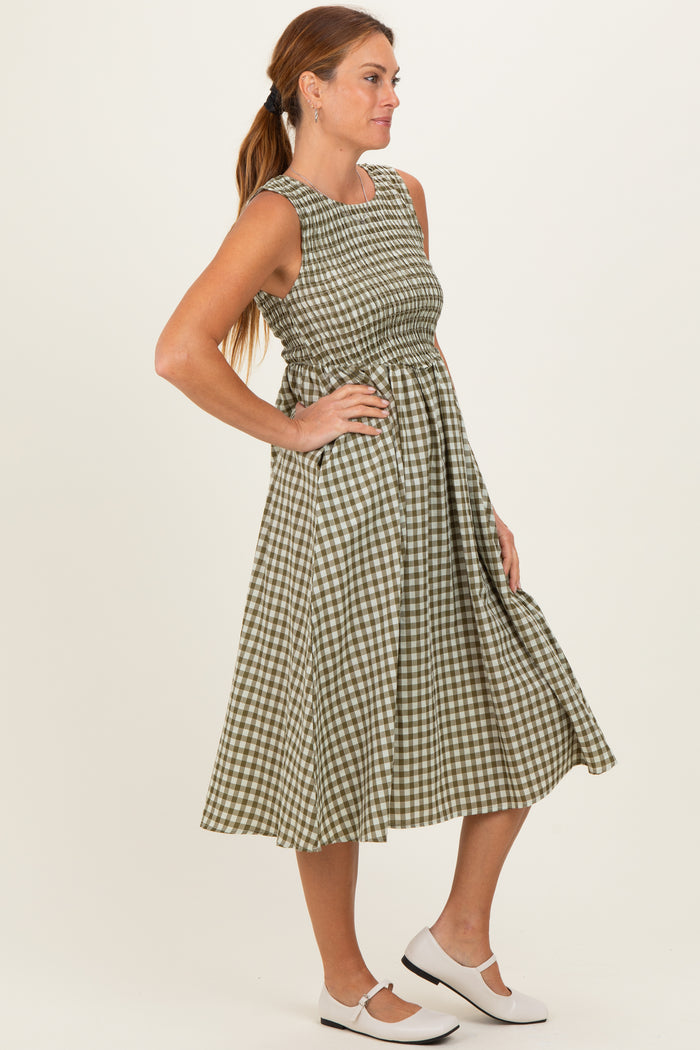 woman wearing a green and white gingham sleeveless dress with a fitted bodice and flared skirt