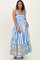 woman wearing a blue and white striped maternity maxi dress with tie straps and a floral print at the hem, holding her baby bump
