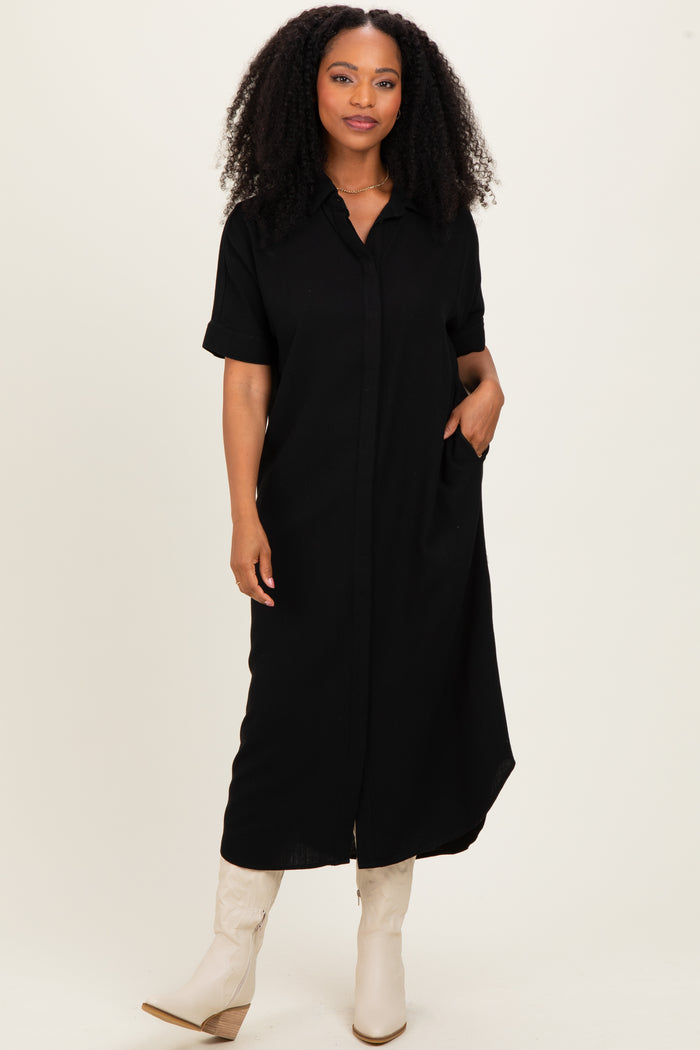 woman wearing a black short sleeve button-up maxi dress with pockets and styled with beige knee-high boots