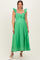 woman wearing a green maternity dress with ruffle straps and a cutout detail, standing and smiling
