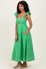 woman wearing a green midi dress with ruffled straps and side pockets