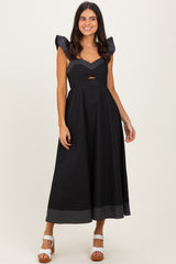 woman wearing a black midi dress with flared sleeves and a cut-out detail at the waist