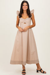 woman wearing a beige midi dress with puff sleeves and a gathered bodice, styled with a striped hemline