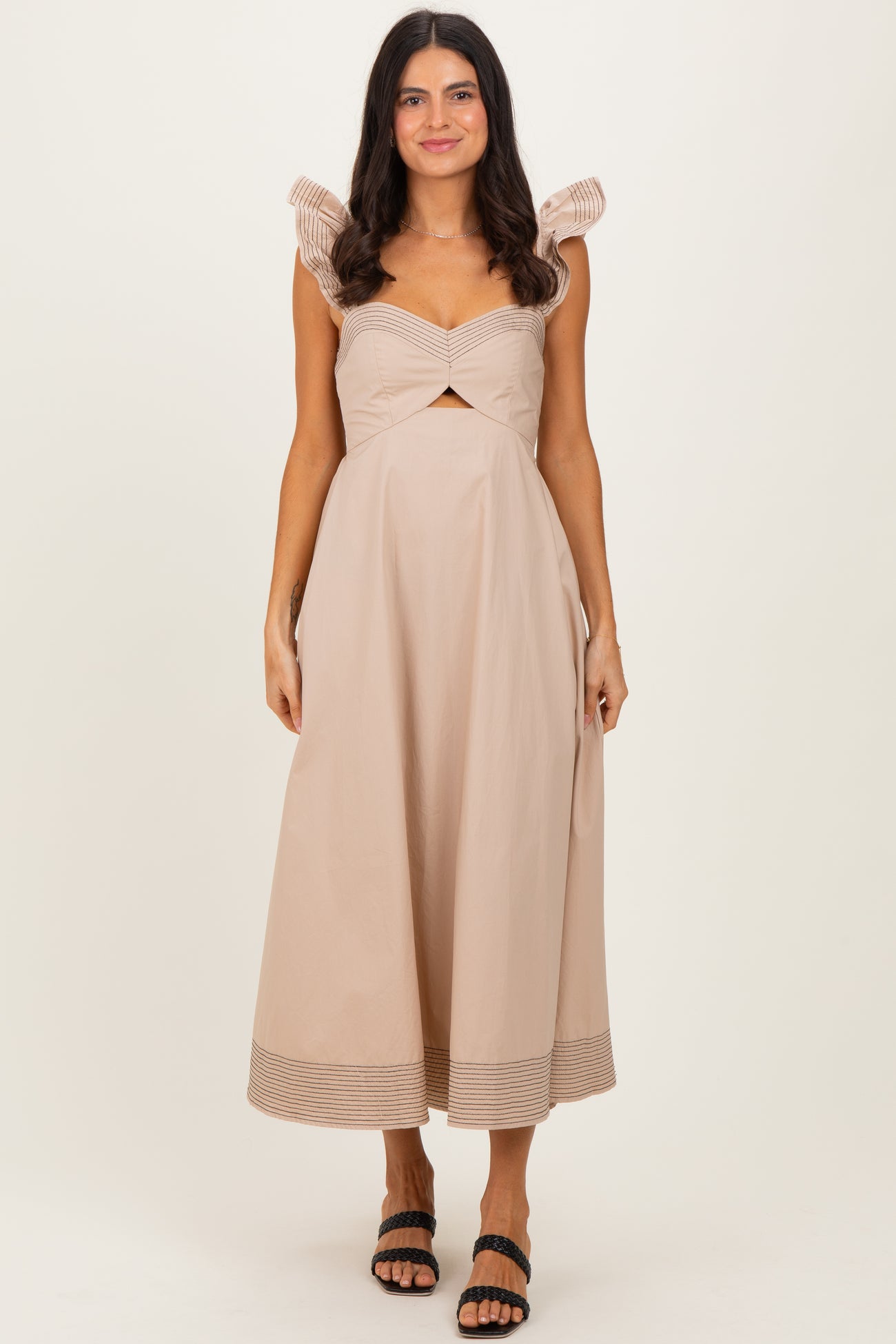 woman wearing a light beige midi dress with pleated sleeves and a twisted front detailing