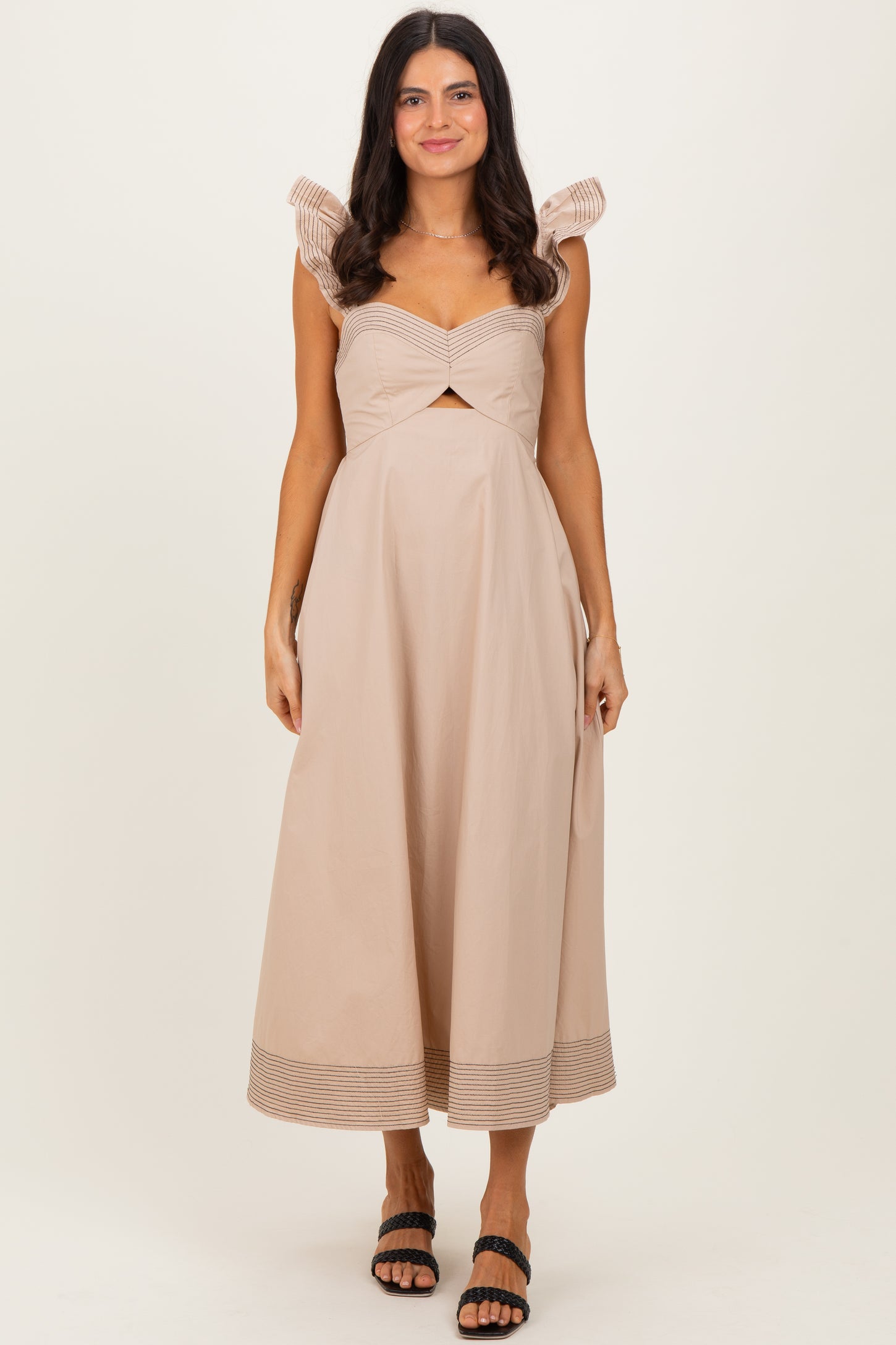 woman wearing a light beige midi dress with pleated sleeves and a twisted front detailing
