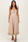 woman wearing a light beige midi dress with pleated sleeves and a twisted front detailing