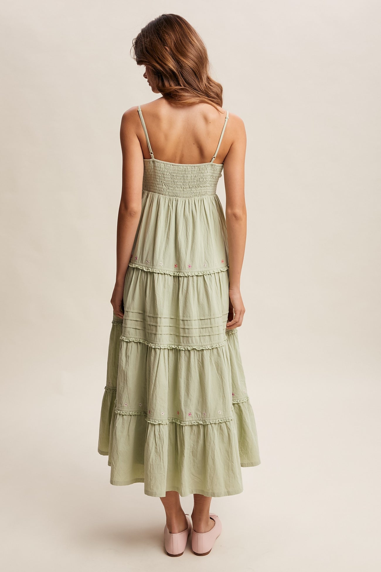 woman wearing a light green tiered maxi dress with a smocked back and adjustable straps