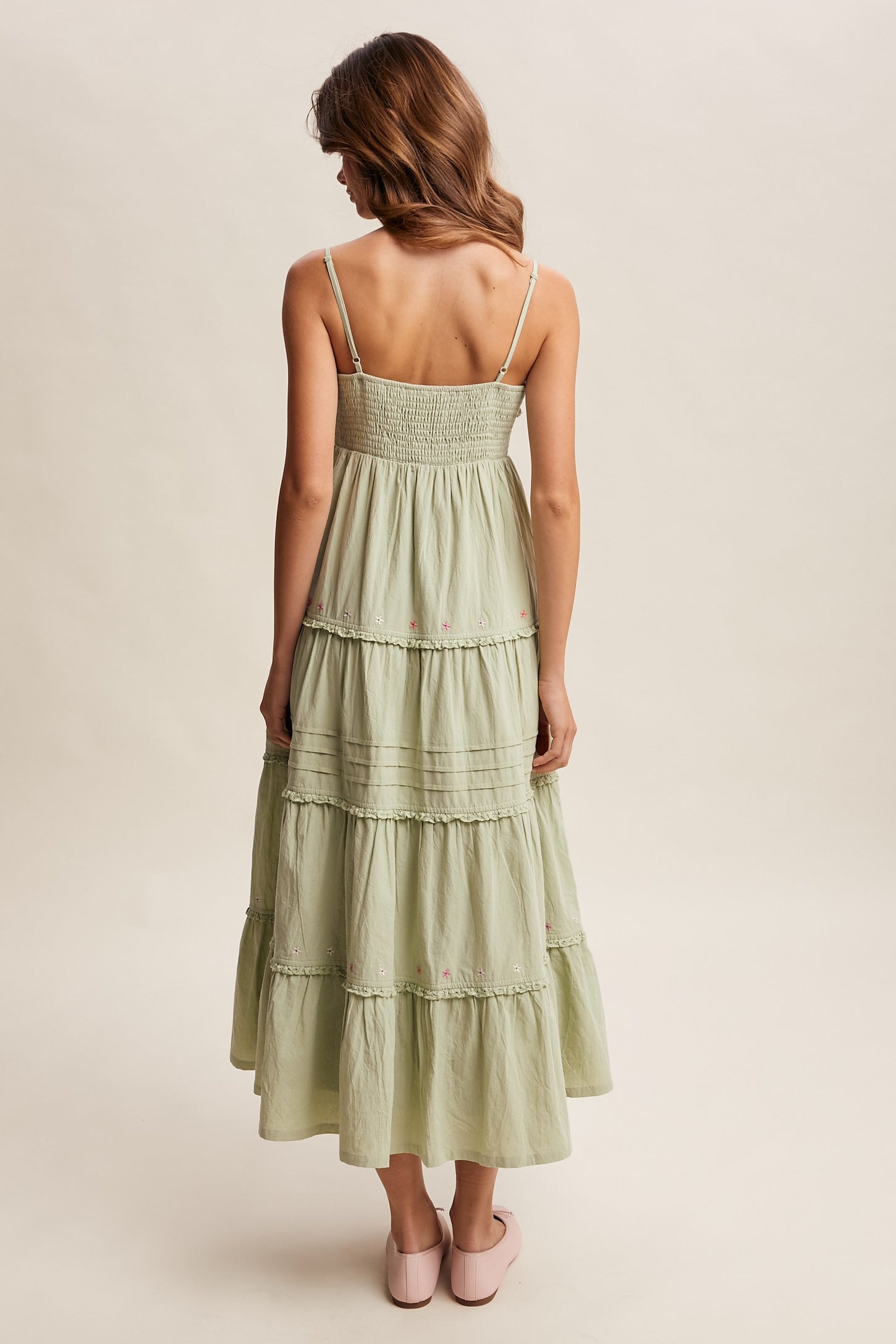 woman wearing a light green tiered maxi dress with a smocked back and adjustable straps