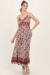 woman wearing a floral maxi dress with a fitted bodice and spaghetti straps, styled with a flowing skirt