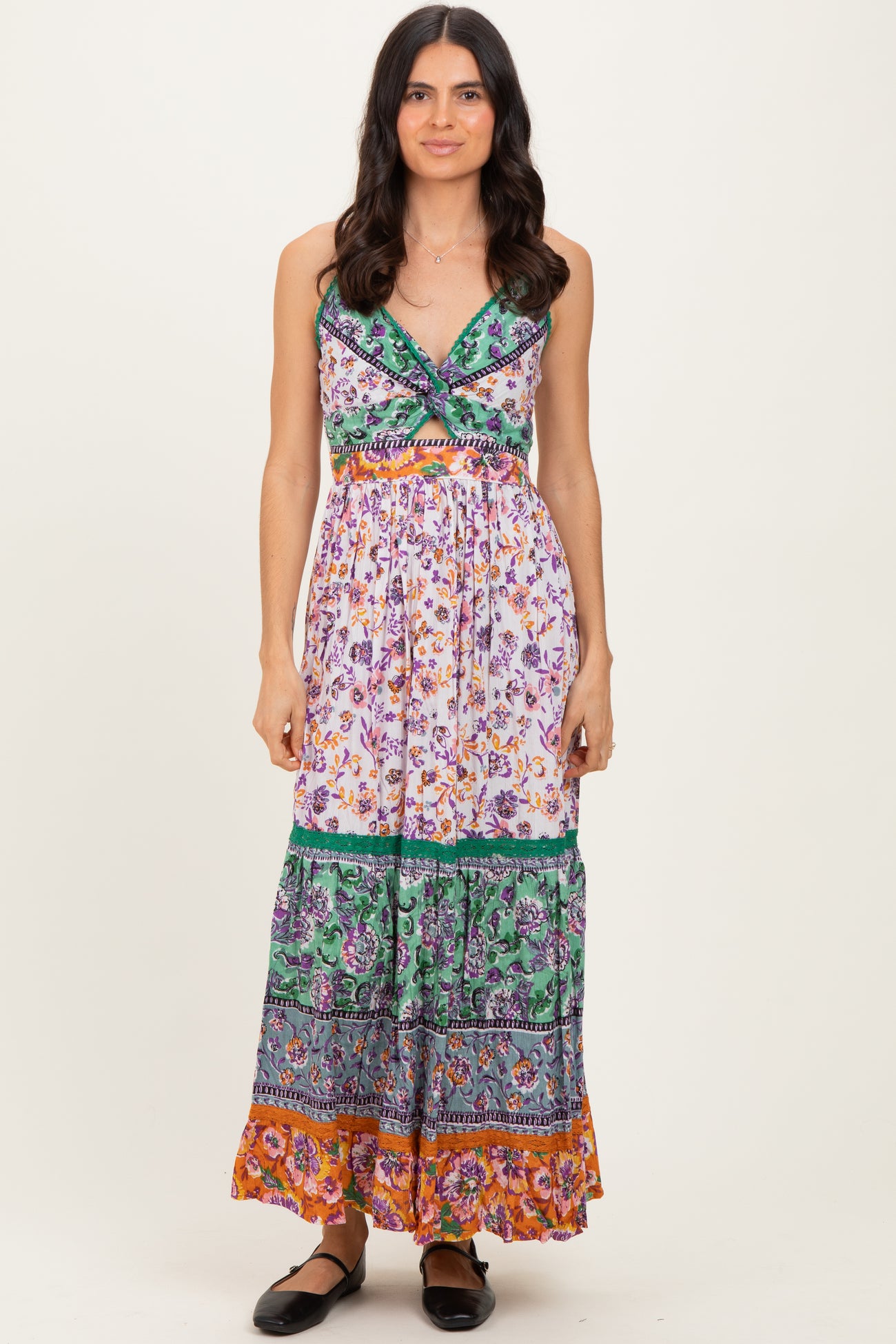 woman wearing a floral print maxi dress with a deep V-neckline and colorful tiered hem