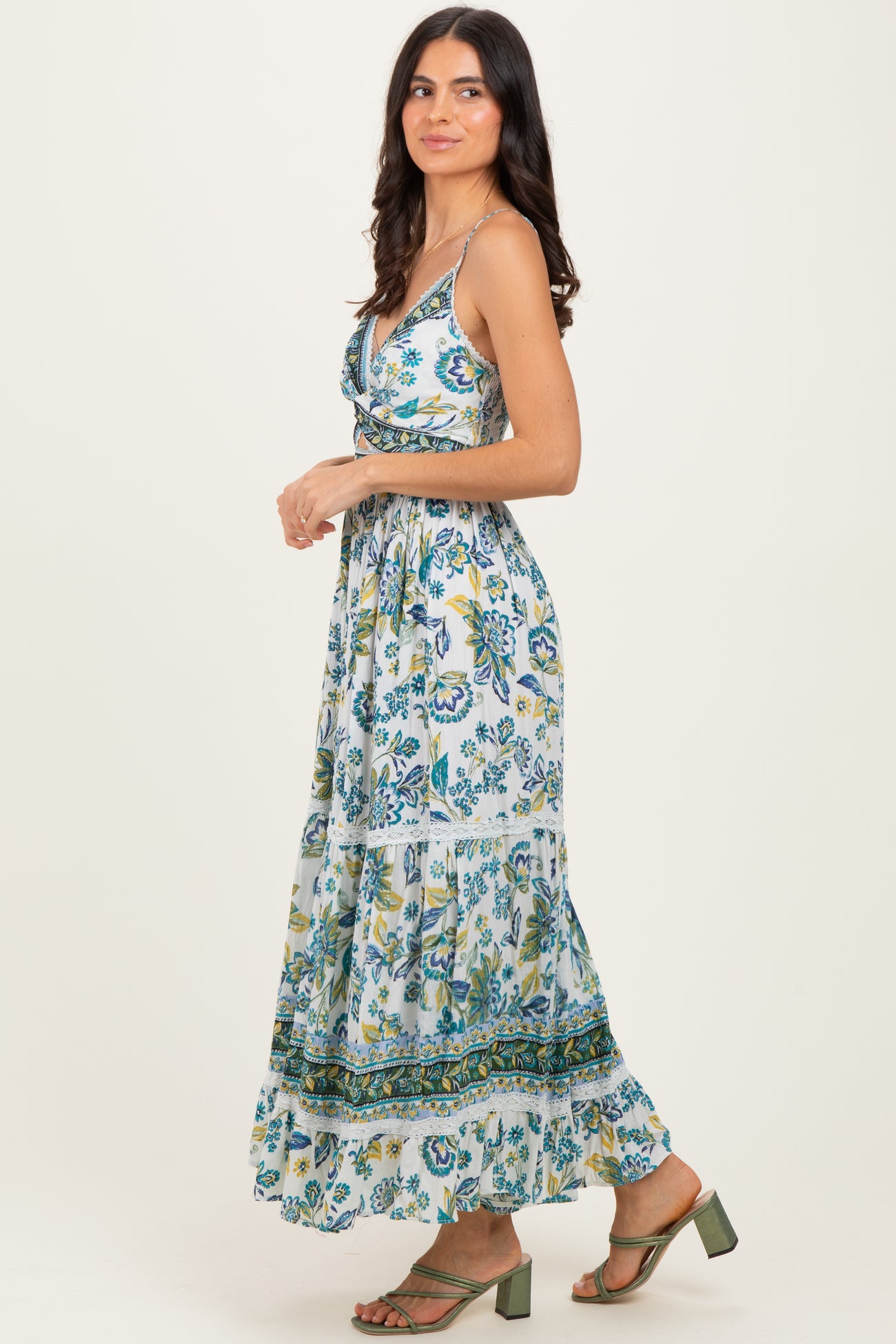 woman wearing a blue and green floral maxi dress with spaghetti straps and a tiered skirt