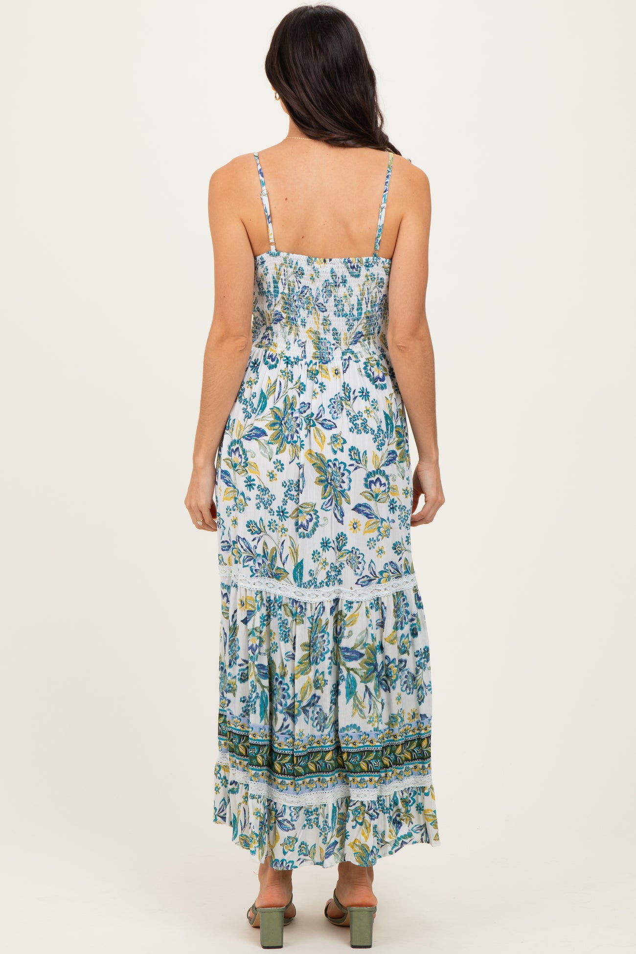 woman wearing a floral print maxi dress with adjustable straps and tiered ruffle hem