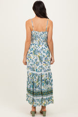 woman wearing a floral print maxi dress with adjustable straps and tiered ruffle hem