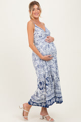 woman wearing a blue and white floral maternity maxi dress and holding her baby bump
