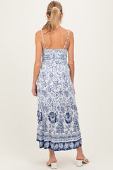 woman wearing a blue and white floral maternity maxi dress with spaghetti straps and a smocked back